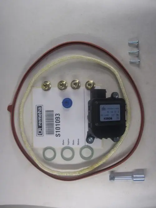 Remeha Motor, Zubehörset mit Steuergerät, elastischen Dichtungen, Schrauben und Drähten auf einer hellen Unterlage.